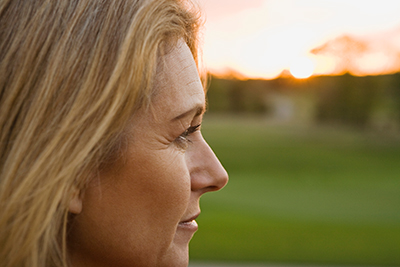 Distant Caregivers Image - Woman looking in distance, thinking of aging mother